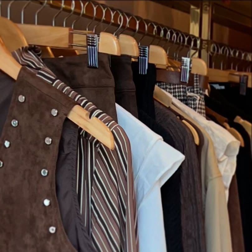 Un portant de la boutique : daim, rayures et chemises claires
