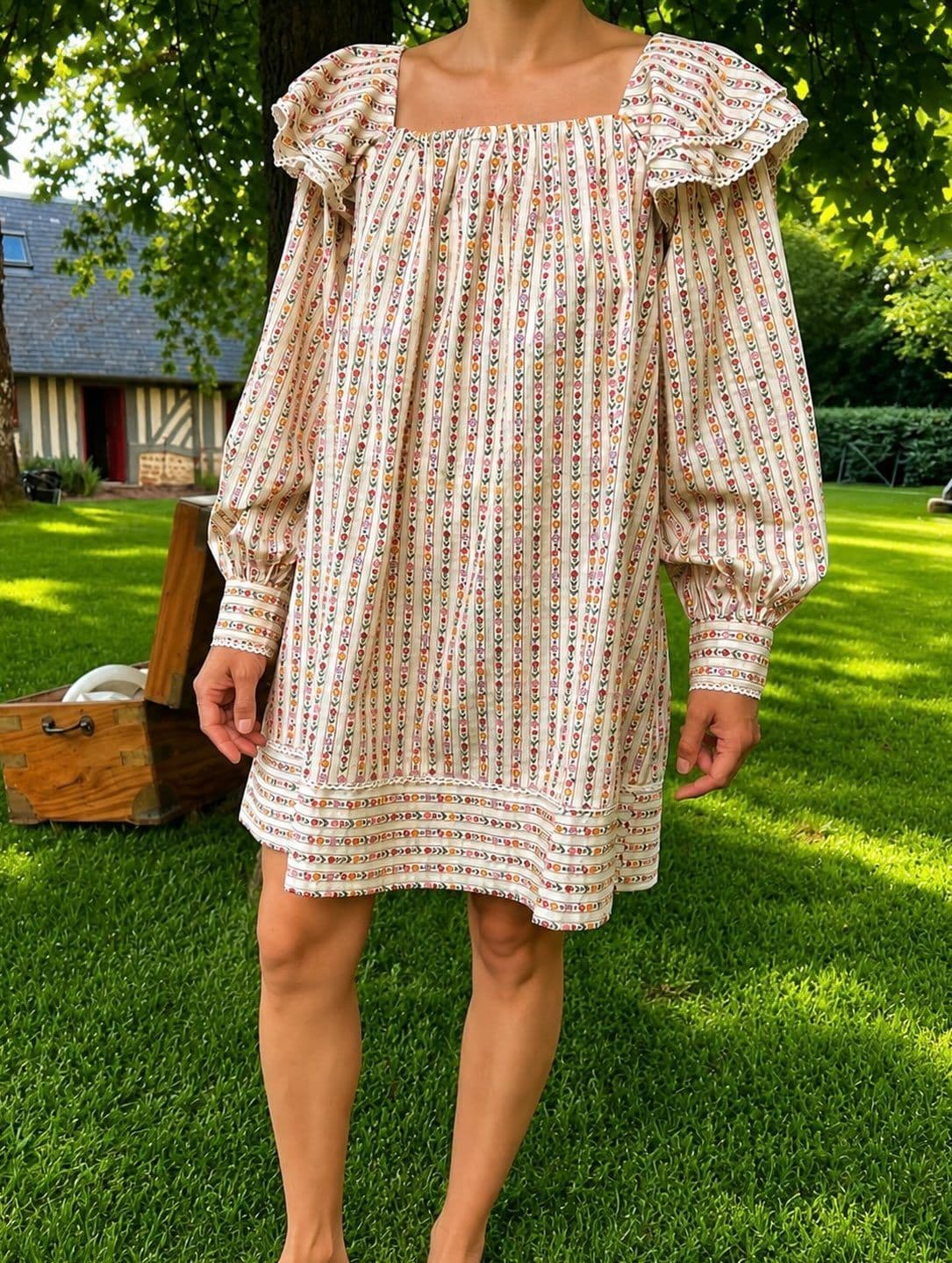Robe imprimée à manches bouffantes, portée dans un jardin