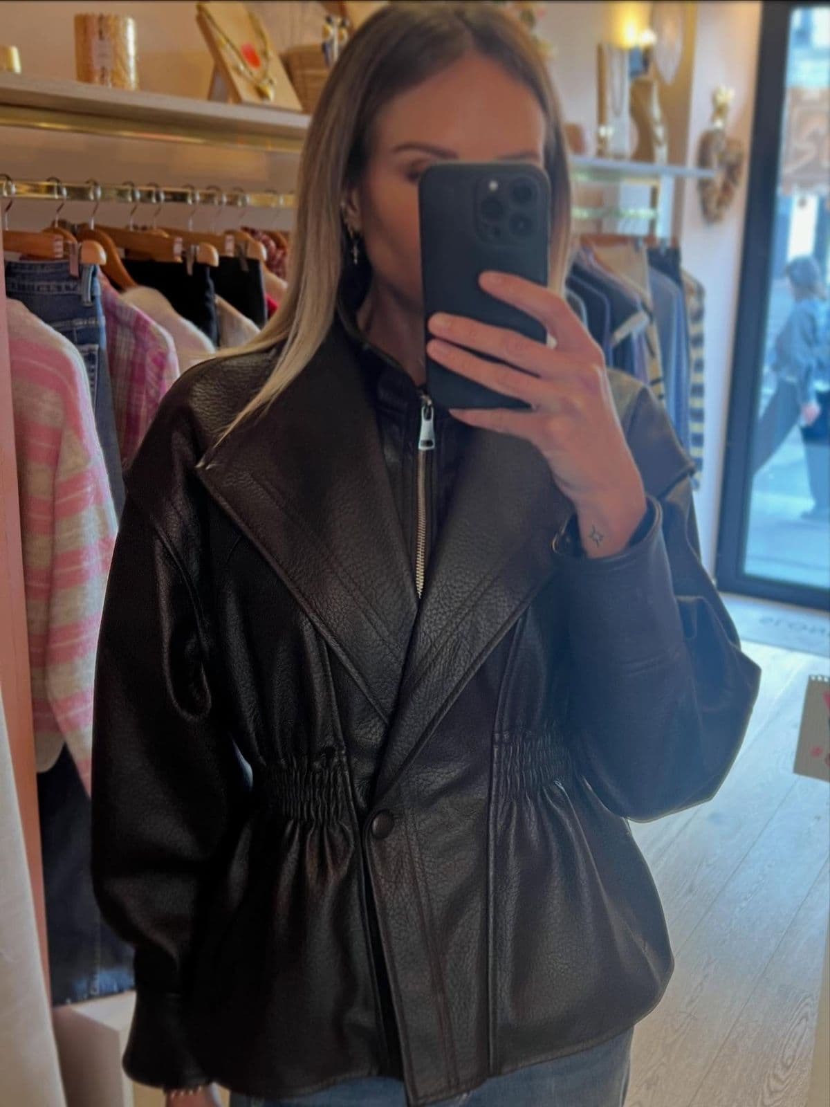 Veste en cuir essayée devant le miroir de la boutique